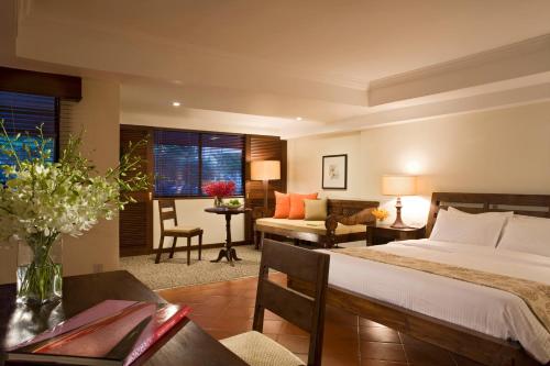 York Hotel في سنغافورة: غرفة نوم مع سرير وغرفة معيشة