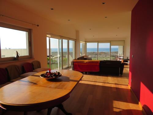 a living room with a table and a couch at Casa da Murtinheira in Quiaios