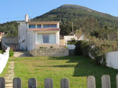 a house with a hill in the background at Casa da Murtinheira in Quiaios