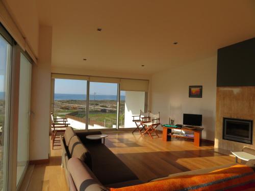 a living room with a large couch and a television at Casa da Murtinheira in Quiaios