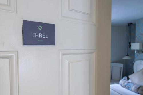 a sign on a wall above a door in a room at The Wychwood Inn in Shipton under Wychwood