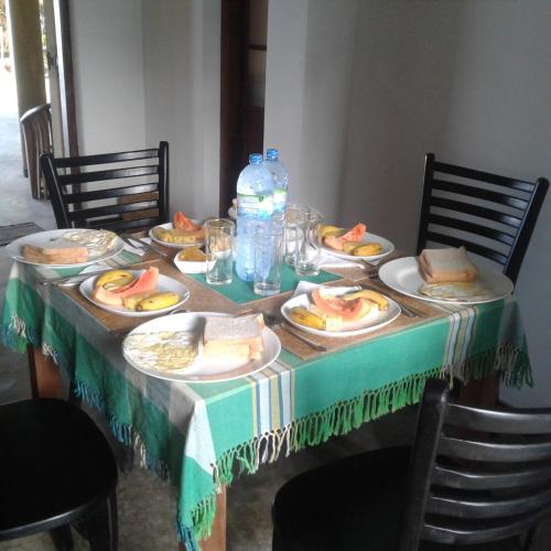 una mesa con platos de comida y botellas de agua en Asiri Yoga Retreat, en Galle