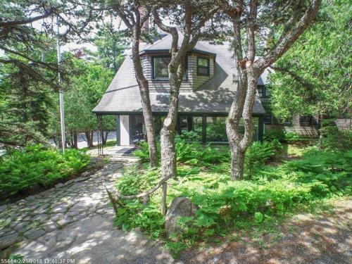 a house with a group of trees in front of it at Harbourside Inn in Northeast Harbor