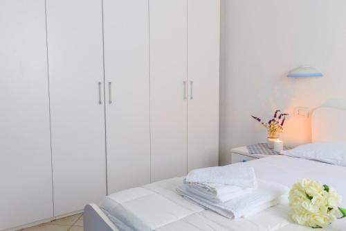 オルビアにあるSanpietroburgo 22の白いキャビネットとベッド付きの白いベッドルーム
