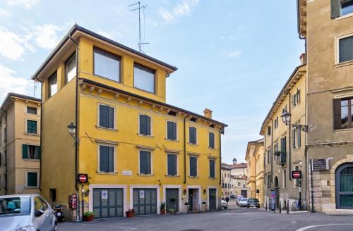 ヴェローナにあるRelais Ponte Pietraの通路脇の黄色い建物
