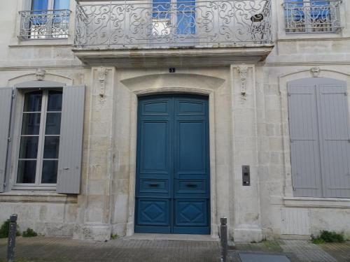une porte bleue sur le côté d'un bâtiment dans l'établissement Calme et sérénité, à La Rochelle