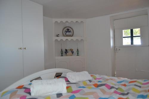 a bedroom with a bed with two towels on it at Casal São João Cottages 106 in Fajã da Ovelha