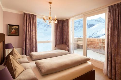 a room with two ottomans in front of a window at Hotel Bergwelt in Obergurgl