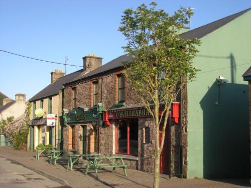 a brick building with picnic tables on a street at Wild Kerry Lodge in Glenbeigh