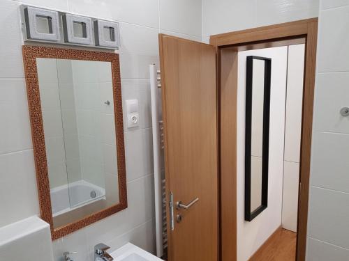 ブダペストにあるRenaissance Studio Apartmentのバスルーム(鏡、木製のドア付)