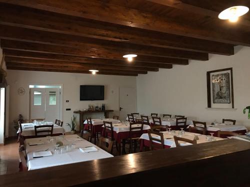une salle à manger avec des tables, des chaises et une télévision dans l'établissement Agriturismo L'Ulivo, à Padula
