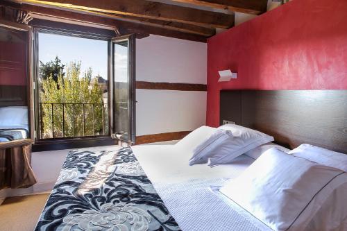 a bedroom with a large bed with a large window at Pintor El Greco in Toledo