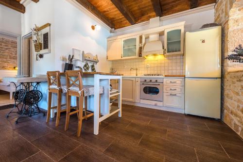 una cucina con frigorifero e tavolo con sedie di Rural house Mudrinic "Ivini dvori" a Bogatić