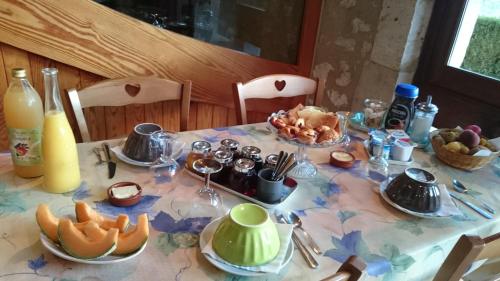 einen Tisch mit einem Tischtuch mit Essen drauf in der Unterkunft Domaine Jardin d'En Naoua in Maubec