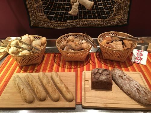 a table with baskets of bread and baskets of food at Hotel Bamboo in Coldrano