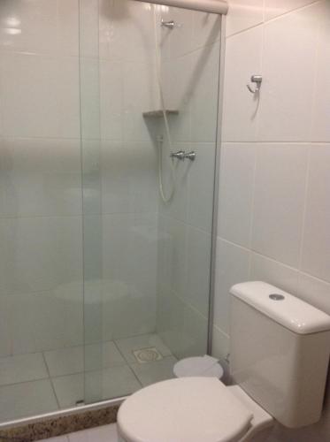 a bathroom with a toilet and a glass shower at Pousada Recanto Sol a Sol in Cabo Frio