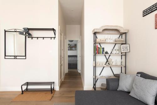 een woonkamer met een bank en een boekenplank bij Cozy & Bright Apartment in Antwerpen