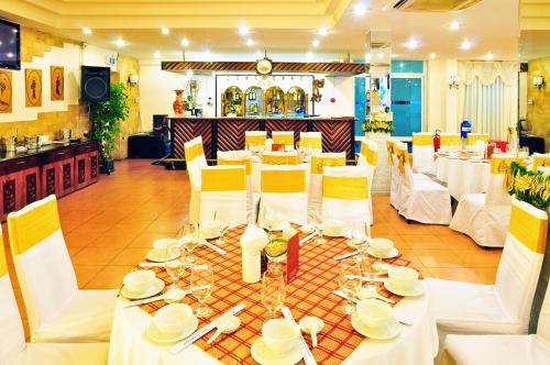 ホーチミン・シティにあるキー ホア ホテル ホーチミンのダイニングルーム(白いテーブル、黄色の椅子付)