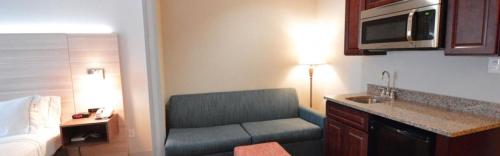 una sala de estar con sofá en una habitación de hotel en Holiday Inn Express Toledo-Oregon, an IHG Hotel, en Oregon