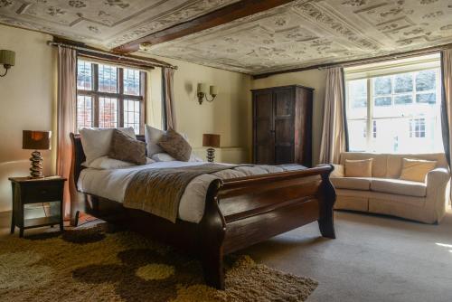 a bedroom with a bed and a couch and windows at Sutherland House in Southwold