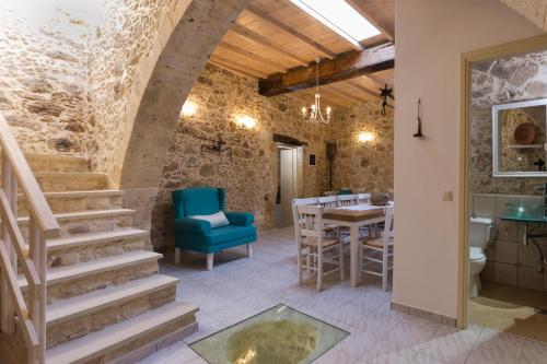 a room with a staircase and a table and chairs at Trigono Kaliviani, 4BDR - 3BR - 8 people in Kissamos