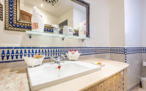 a bathroom with a sink and a mirror at Hotel & Ryad Art Place Marrakech in Marrakech