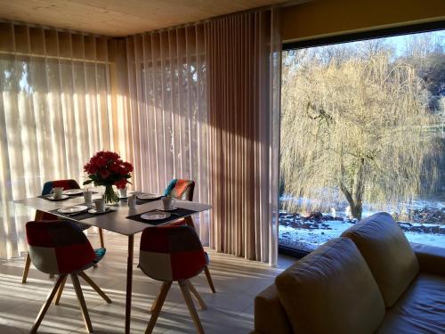 a living room with a table and chairs and a large window at Ferienhaus HAAGALM in Primstal
