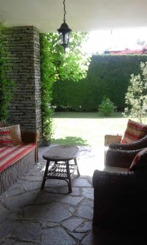 a patio with a table and a couch and a lamp at Villa Cristina in Vezzo