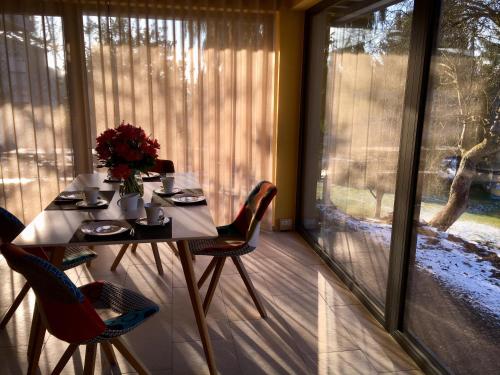 a table and chairs in a room with a window at Ferienhaus HAAGALM in Primstal