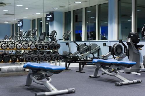a gym with several rows of treadms and machines at Leonardo Royal Southampton Grand Harbour in Southampton