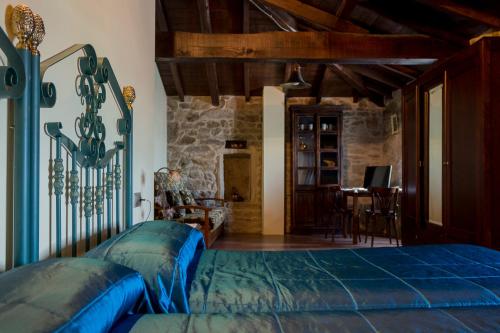 um quarto com uma cama azul e uma mesa em Casa Roan y Casa Grande em Lodoso