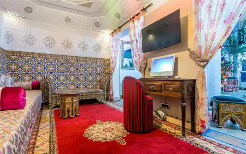 a living room with a couch and a tv at Hotel & Ryad Art Place Marrakech in Marrakech