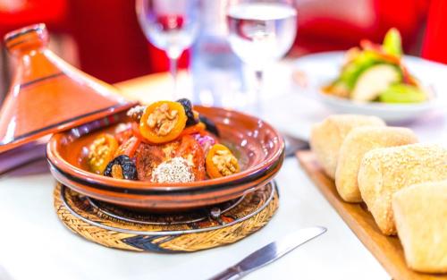 a bowl of food on a table with bread at Hotel & Ryad Art Place Marrakech in Marrakech