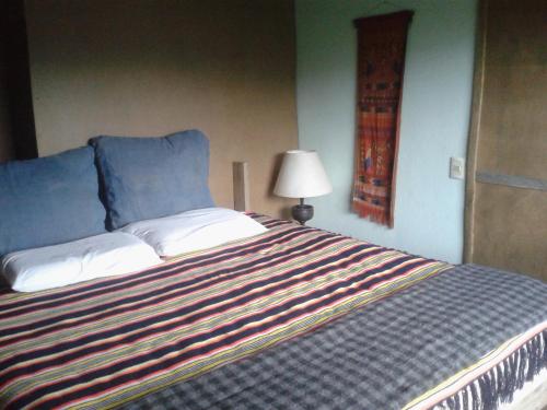 a bedroom with a bed with a striped blanket at apto con vista al mar in La Paloma