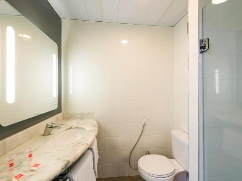 La salle de bains est pourvue d'un lavabo, de toilettes et d'un miroir. dans l'établissement ibis Campinas, à Campinas