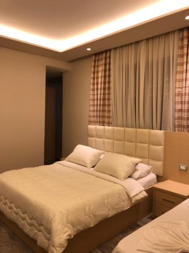 a bedroom with a large bed and a window at Hotel Lungomare in Vlorë