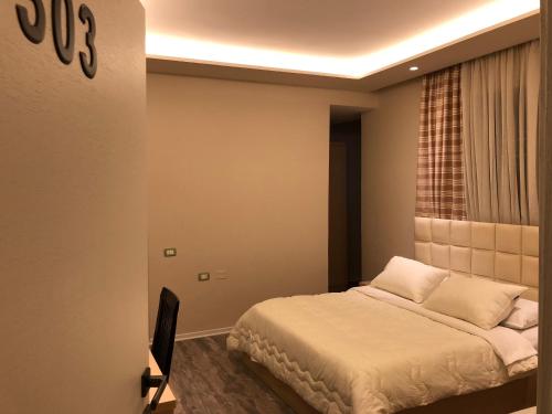 a bedroom with a bed and a tv in it at Hotel Lungomare in Vlorë