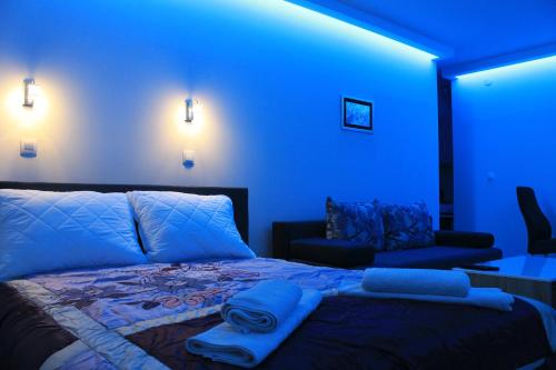 a blue room with a bed and a couch at "E&S" Apartment in Mostar