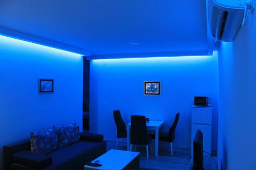 a blue room with a couch and a table with chairs at "E&S" Apartment in Mostar