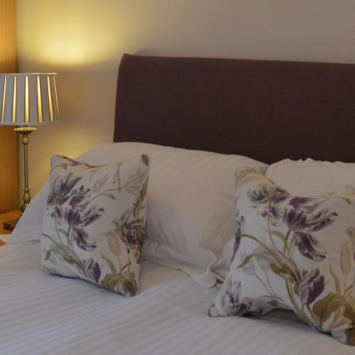a bed with two pillows on top of it at Balnearn House in Aberfeldy