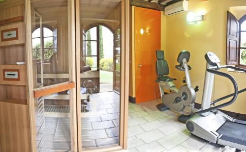 a fitness room with a treadmill and a gym at Residenza Storica Casale Pozzuolo in Cinigiano
