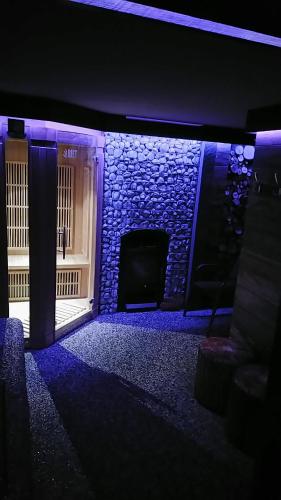 a room with a tv and a wall with blue lights at Privat LeNa in Ružomberok