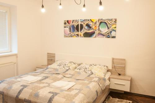 a bedroom with a bed and a painting on the wall at Apartment Cajakova in Košice