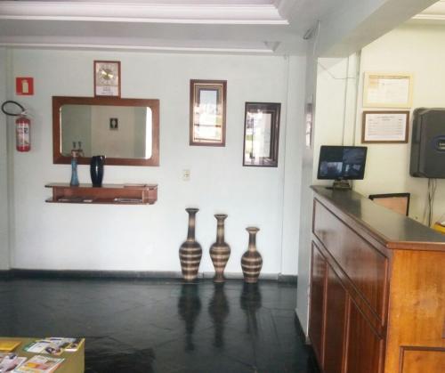 Chambre avec 3 vases sur un mur avec un miroir dans l'établissement San Marino Hotel, à São José dos Campos