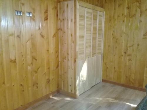 an empty room with wooden walls and a door at Cabañas Los Canelos Pucon, Hermosa Granja de 20 hectaréas a orillas del Río Liucura in Pucón