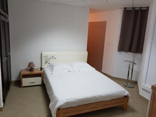 1 dormitorio con 1 cama blanca en una habitación en Hello Guyane- Le luxe au coeur de Cayenne, 8 en Cayenne