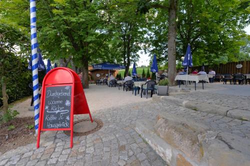 a chalkboard sign sitting on a sidewalk in a park at Gasthof Kolb in Bayreuth