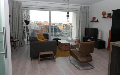 a living room with a couch and a tv at Appartement aan Zee in Ostend