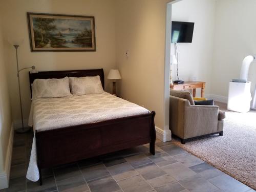 a bedroom with a bed and a couch and a chair at Riverview B&B in Gananoque