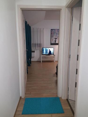 a hallway with a television in a white room at Apartmány Tylovice in Rožnov pod Radhoštěm